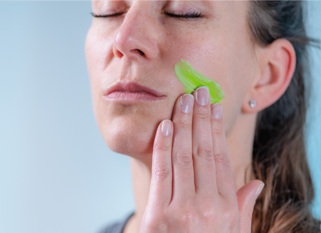 Woman applying Body Guac hemp-based topical to her face as part of a natural skincare routine